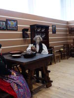 Mannequin in traditional Czech dress seated at country house table