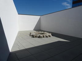 wheel-like stone lying on roof (title “Shadow of the sun”)