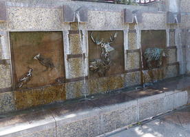 Metal animal sculptures as reliefs on a fountain