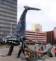 Metal and colored glass sculpture of mother and baby whale