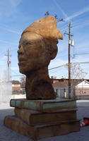 Sculpture of a person’s head atop a stack of three books