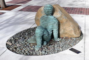 Bluestone and bronze sculpture of a reclining man