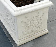Reliefwork of flowers on white stone planter