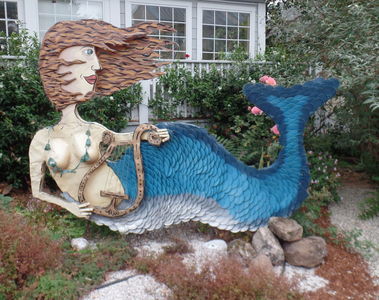 Sculpture of mermaid with brown hair and sea-blue tail