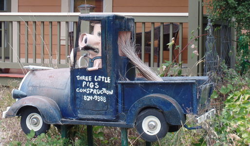 Blue “Three Little Pigs Construction” pickup truck with pig driving