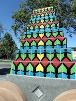 pyramid of tiles with stick figures on them; title of work is “Families and Youth”