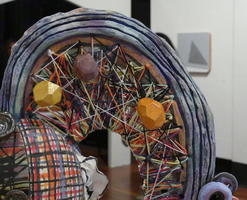 Closeup of ceramic string sculpture with polyhedral stones
