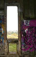 Window in building with graffitti on walls at side