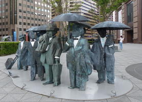blocky sculpture people with umbrellas