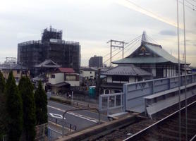 Pagoda-style building in foreground; building under construction in background.