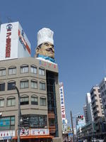 Giant head of man wearing toque on top of another Niimi building
