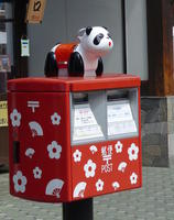 post box with panda figurine atop