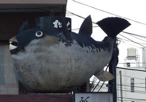 fat fish statue above restaurant