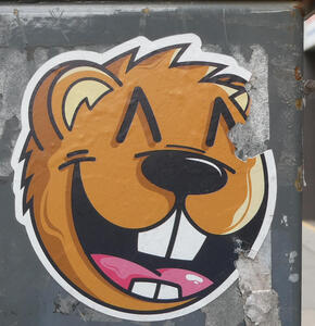 Sticker showing head of a widely smiling brown beaver
