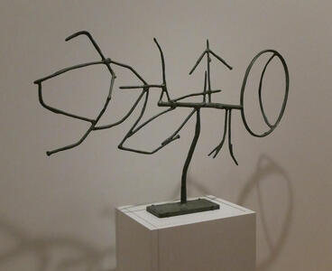 Sculpture made of what appear to be sticks in vaguely letter-like shapes.