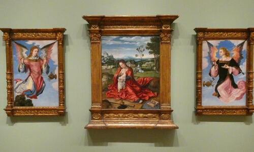 Three paintings: at left and right are angels facing the middle painting of madonna and child