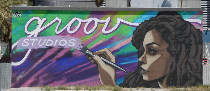 Woman holding paintbrush; text is: groov studios