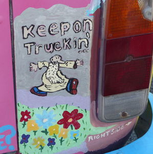 R Crumb's “Keep on Trucking” man painted on rear bumper of VW van.