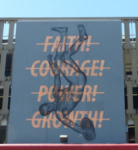Words “faith courage power growth” crossed out superimposed over image of discus thrower upside-down.