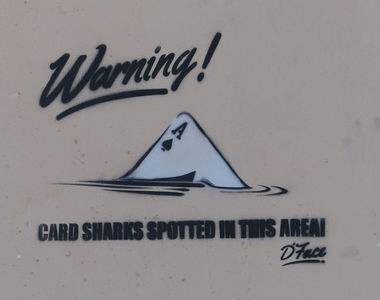 “Warning! Card Sharks spotted in this area”; with Ace at angle looking like shark's fin moving through water.