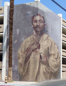 Mural of man with moustache painted on three-story parking garage corner