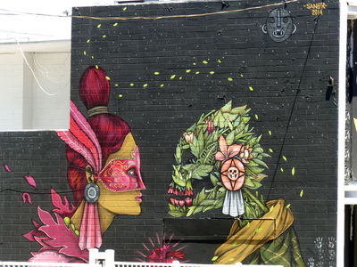 Woman in red mask facing skull made of leaves and flowers