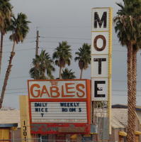 Sign “The Gables Mote(l)” at boarded-up hotel