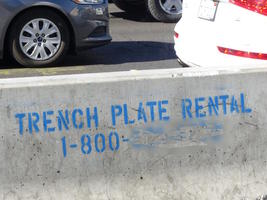 Concrete barrier labeled “Trench Plate Rental”