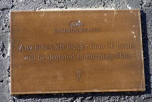 Plaque reading “Any bikes left longer than 36 hours will be donated to Burning Man.”