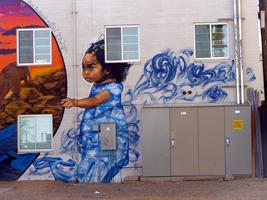 Part of mural; child in blue dress that dissolves into smoke swirls