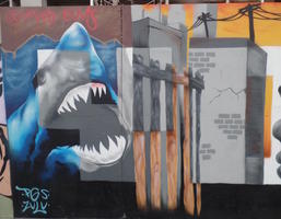 Mural panel showing a shark behind a fence