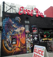 Storefront with painting of dragon eating pizza.