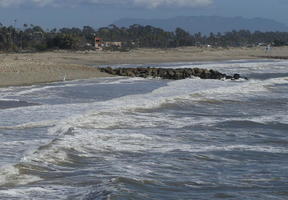 Ocean waves in foreground, beach in background