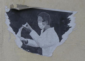 Partial sticker showing scientist with mask over nose and mouth pouring liquid into a beaker