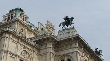Top of building with statue of person on winged horse