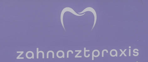 Sign for dentist’s office with two curved lines representing a tooth.