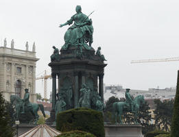 Statue of seated woman on top, men on horseback below
