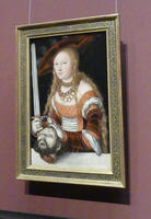 Woman with sword; head of man on table in front of her