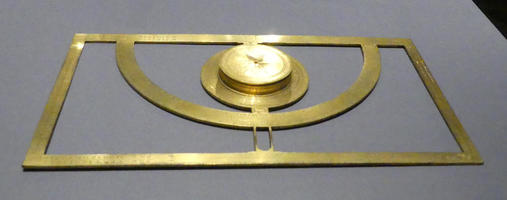 Instrument that looks like a  directional compass and protractor in a rectangular frame