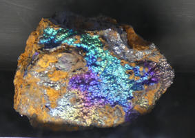 Mineral with yellow, purple, blue, and green iridescent markings