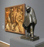 Sculpture of man in hat and cape, head bowed