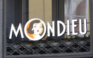 Sign MONDIEU, with picture of shocked-looking woman in the O.