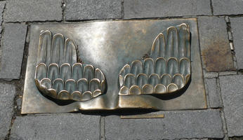 Rectangular metal plate with wings design embedded into brick streets