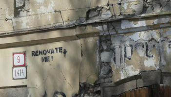 Crumbling building with stencil: Renovate me!