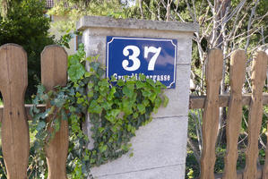 House sign with vines and fence