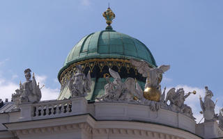 Green dome with statues of angels and warriors at base