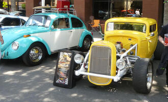 Turquoise VW Beetle on left, yellow roadster on right
