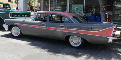 Long gray car with red accent and roof; car has tailfins