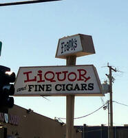 Two-part sign for Frank’s Liquor and Fine Cigars; each part is trapezoidal in shape