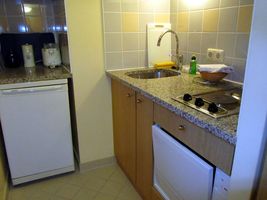 Kitchen area with sink, refrigerator, stovetop, and dishwasher